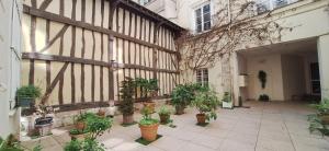 a courtyard with potted plants on the side of a building at Saint Maclou Plein Centre Rouen Malpalu - Linge & Ménage Inclus in Rouen