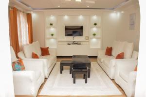 a living room with two white couches and a table at The π Homes in Eldoret