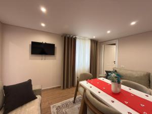 a living room with a table and a television at Guest House Deon in Vlorë