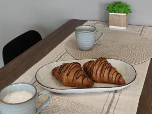 a table with a plate of croissants and two cups of coffee at ILLU Resort in Orhei +19 photos
