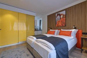 a bedroom with a large bed with orange pillows at Franziskaner by Centra in Zurich