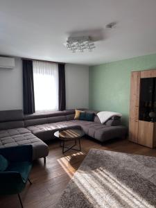 a living room with a couch and a table at Bright & Cozy Apartment in Villach