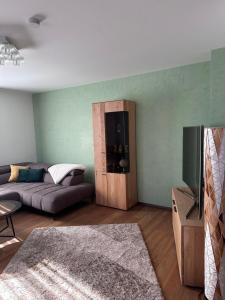a living room with a couch and a tv at Bright & Cozy Apartment in Villach