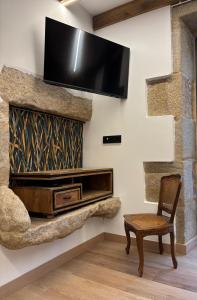 a living room with a tv hanging on a wall at Casa do Cabo in Morás +46 photos