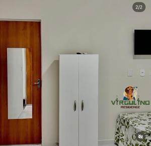 a bedroom with a white cabinet and a mirror at Virgulino Residence in Piranhas
