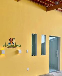 a yellow wall with a sign on the side of a building at Virgulino Residence in Piranhas