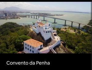 a building on a cliff with a bridge in the background at Casa Branca in Vila Velha