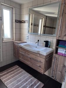a bathroom with a sink and a mirror at Bright & Cozy Apartment in Villach +9 photos