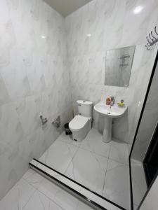 a white bathroom with a toilet and a sink at Hostel Mevazor in Katartal +99 photos