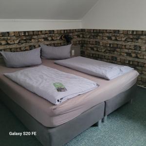 two beds in a room with a brick wall at Parkhotel Schwedt in Schwedt