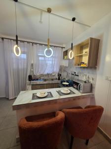 a kitchen with two chairs and a counter in a kitchen at Rio Cabins in Nyeri