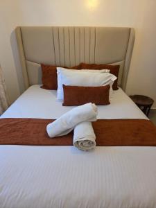 a hotel room with a bed with towels on it at Rio Cabins in Nyeri