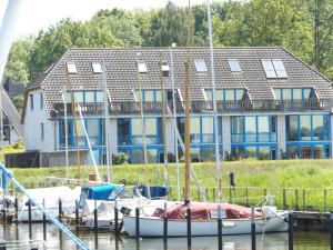 a group of boats docked in front of a house at Ferienwohnung Strickert in Stexwig in Stexwig