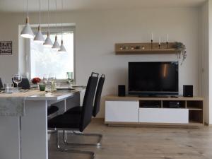 a dining room with a table and a television at Ferienwohnung Strickert in Stexwig in Stexwig