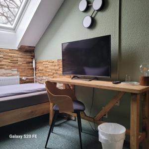 a bedroom with a desk with a television and a bed at Parkhotel Schwedt in Schwedt