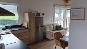 a kitchen with a refrigerator and a couch and a table at Mirando a los Picos de Europa in Potes
