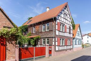 a red and white house with a red fence at Olive Garden in Groß-Bieberau