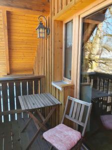a wooden table and a chair on the porch of a cabin at Biohof Prannleithen - Knusperhaus in Yspertal +8 photos
