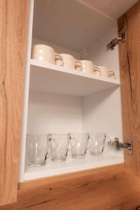 a shelf with cups and bowls on it at Luxury Residence in Baia Mare +63 photos