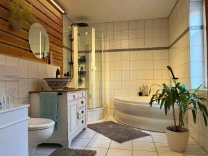 a bathroom with a tub and a toilet and a sink at Olive Garden in Groß-Bieberau