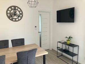 a dining room with a table and a clock on the wall at Domček in Budimír