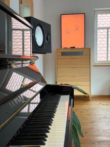 a piano in a living room with a speaker at Olive Garden in Groß-Bieberau +25 photos