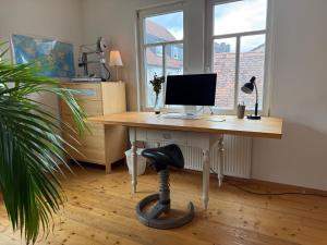 a desk with a computer and a chair in a room at Olive Garden in Groß-Bieberau