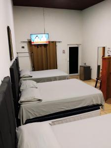 a room with four beds and a tv on the wall at Hotel Ejecutivo VIP, La Paz in La Paz