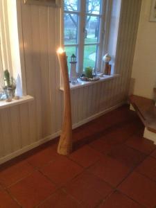 a wooden floor lamp in a room with a window at Ferienhaus von der Ahe in Mohrkirch