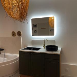 a bathroom with a sink and a mirror and a tub at Love room - Montélimar in Montélimar +1 photo
