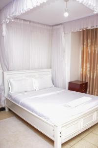 a white bed with a white canopy in a bedroom at The π Homes in Eldoret
