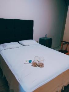 a bed with two slippers and a remote on it at Hotel Ejecutivo VIP, La Paz in La Paz +11 photos