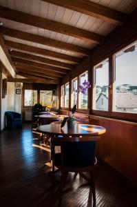 a dining room with tables and chairs and windows at Lo Chalet da Ilaria in Pescocostanzo
