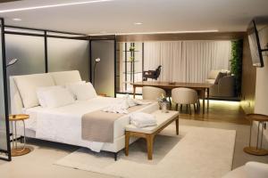a bedroom with a white bed and a dining room at Hotel Pedra Negra Gov. Valadares in Governador Valadares +49 photos