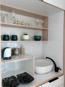 a kitchen with a large white bowl on a shelf at Khayalena Beach House - Tides Reach in Umdloti