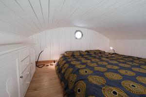 a bedroom with a bed in a white room at La roulotte Ô Cwèrbâs in Gouvy