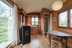 a kitchen and dining room with a table in a house at La roulotte Ô Cwèrbâs in Gouvy