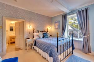 a bedroom with a bed and a window at Tyddyn Llan Restaurant with Rooms in Corwen