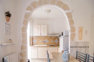 an archway in a kitchen with a white refrigerator at Studio confort, chic & spacieux Plage de Juan les pins & central in Juan-les-Pins