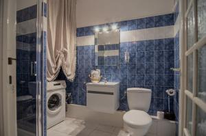 a blue tiled bathroom with a toilet and a washing machine at Studio confort, chic & spacieux Plage de Juan les pins & central in Juan-les-Pins +13 photos