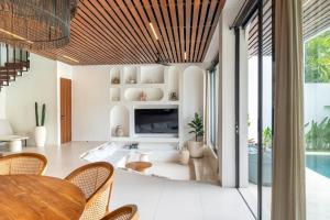 a living room with a fireplace and a table and chairs at Unity Villa 1 Canggu in Canggu