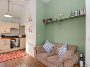 a living room with a couch and a kitchen at Ardpatrick South Lodge in Tarbert