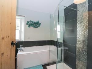 a bathroom with a tub and a glass shower at Ardpatrick South Lodge in Tarbert +18 photos