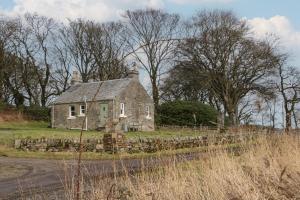 an old stone house on the side of a road at Ardpatrick South Lodge in Tarbert