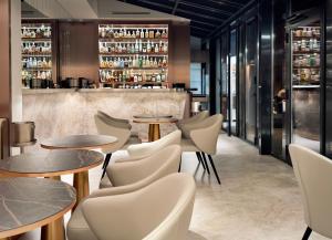 a restaurant with tables and chairs and a bar at Perpetual Elysée Montaigne in Paris