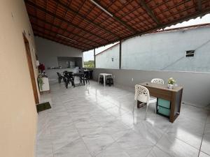 a large patio with tables and chairs and a table at Pousada Buganvília in Tianguá