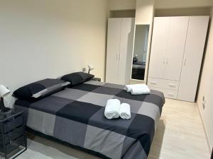 a bedroom with a black and white bed with slippers at CARPI SUITE - Appartamenti Minghetti in Carpi