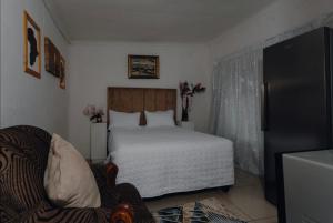 a bedroom with a bed and a chair in a room at HiddenValley in Chartwell