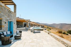 a patio with chairs and a table on a building at Sunset Heaven Villa on Kea in Korissia