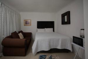 a bedroom with a bed and a chair at HiddenValley in Chartwell